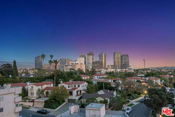Panoramic view of a cityscape with tall buildings and residential houses in the foreground.