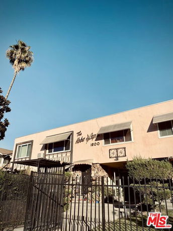 Front view of a two-story building with awnings and gated entrance.