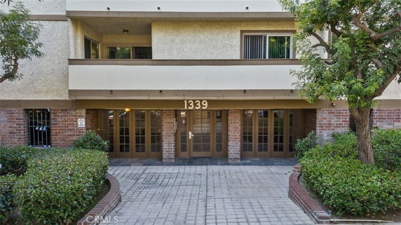 Front view of a multi-story building with an entrance and balcony.