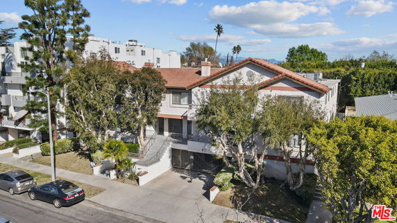 Front view of a two-story residential building with a red-tiled roof and exterior staircases.