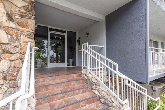 Front entrance of a building with stone accents and a staircase.