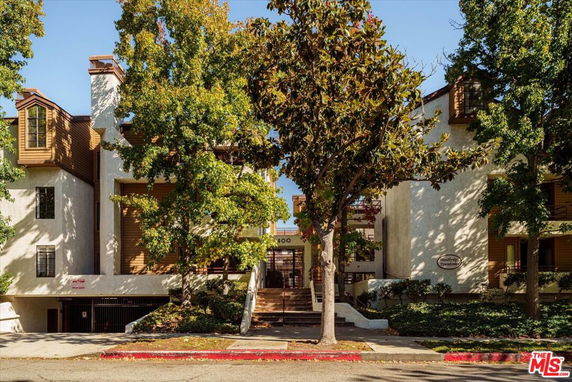 Front view of a multi-story building with trees in front.