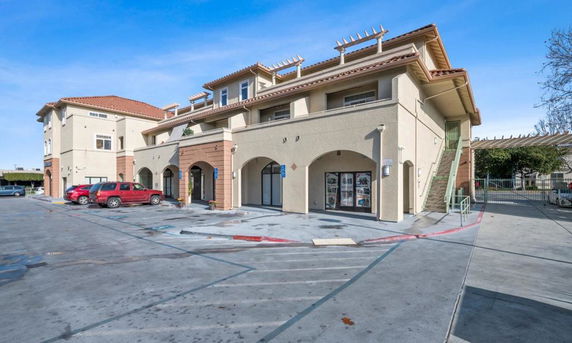Front view of a two-story commercial building with arches and a tiled roof.