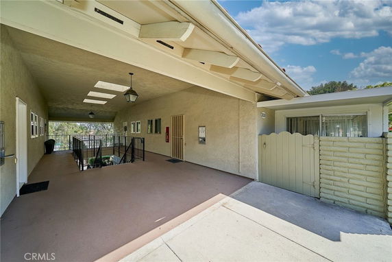 Front view of a building with an open covered area and gated entrance.
