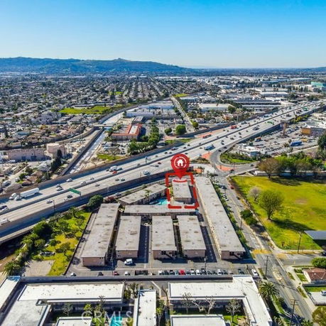Aerial view of a large apartment complex near highways and surrounding urban area.