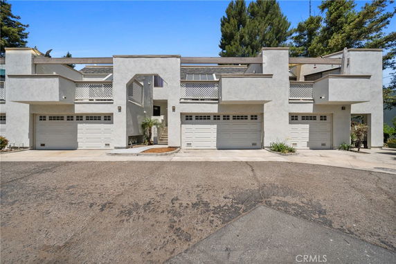 Front view of a townhouse with three garages and a modern facade.