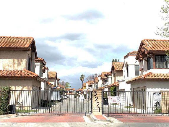 Front view of a gated residential community with two-story townhouses.