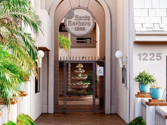 Entrance view of a building with an arched gateway and a metal gate.