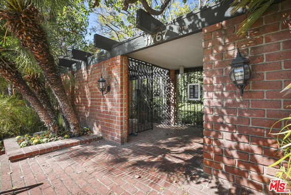 Front view of a brick entrance with a gated doorway.