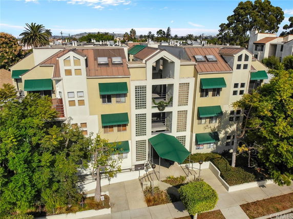 Front view of a multi-story building with green awnings and a central entrance.