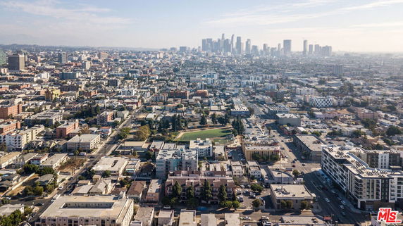 Wide-angle view of a cityscape with numerous buildings and a skyline in the background.