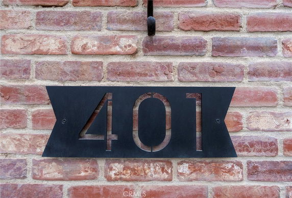 Front view of a brick wall with a metal house number 401