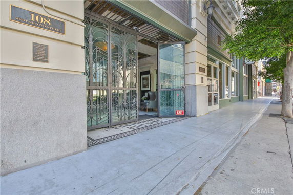 Entrance of a building with decorative iron gates and a sign reading 108 West Second Street.