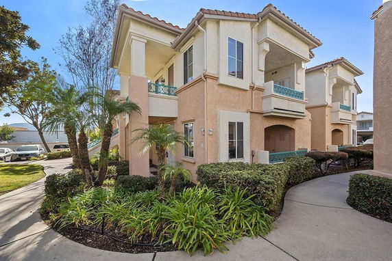 Front view of a two-story residential building with balconies and arched entryways.