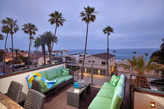 Outdoor seating area on a rooftop with an ocean view.