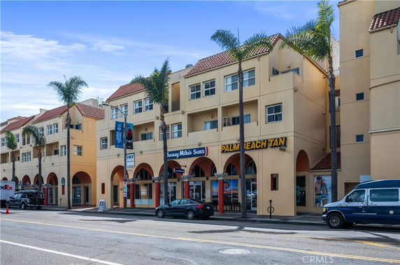 Front view of a multi-story building with retail shops on the ground floor.