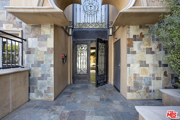 Front entrance of a building with decorative wrought iron door.