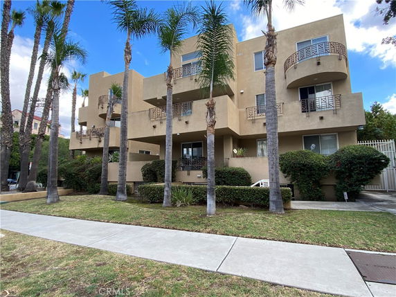 Front view of a multi-story apartment building with balconies.
