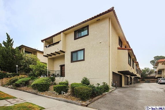 Front view of a multi-story building with garages and balconies.