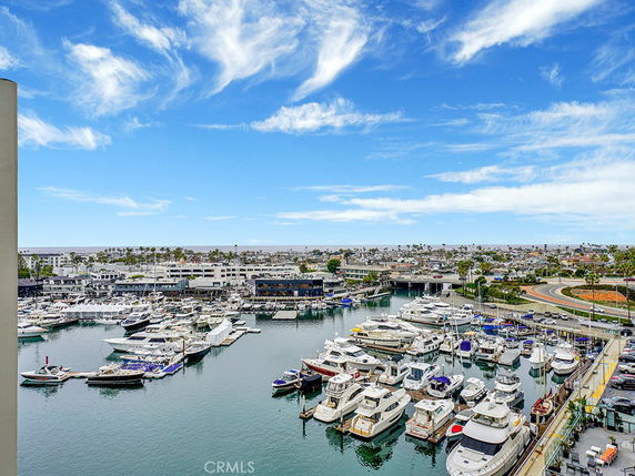 Panoramic view of a marina with numerous boats and buildings in the background.