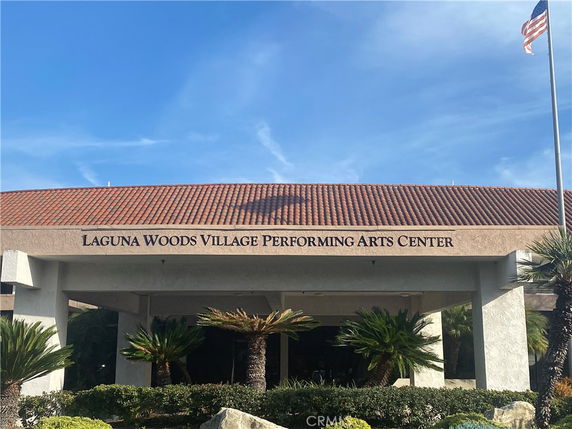 Front view of the Laguna Woods Village Performing Arts Center with a tiled roof and entrance area.