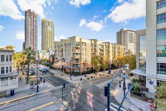 View of a street intersection with surrounding multi-story buildings and high-rise towers.