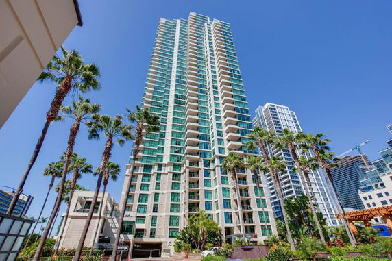 Front view of a modern high-rise residential building with multiple balconies.