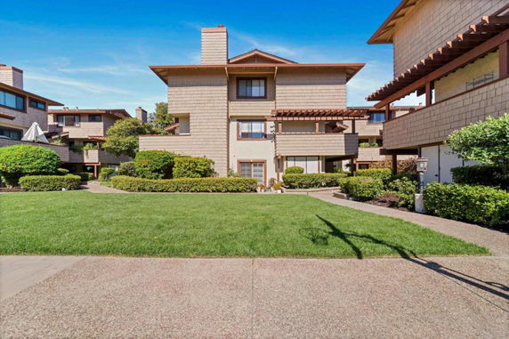 Front view of a multi-story building with a landscaped garden.