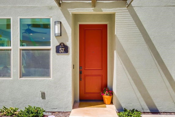 Front view of a house with a red door and two windows.