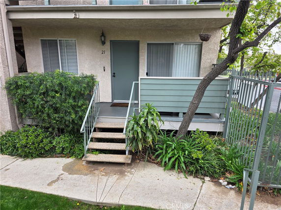 Front view of a residential building unit with steps leading to the entrance.