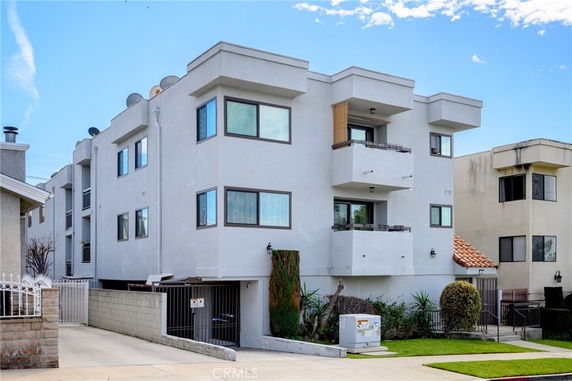 Front view of a multi-story apartment building with balconies.