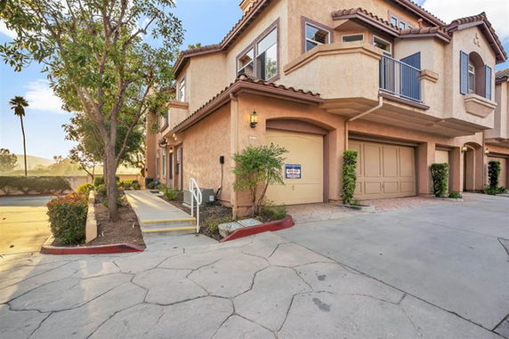 Front view of a multi-story residential building with a garage.