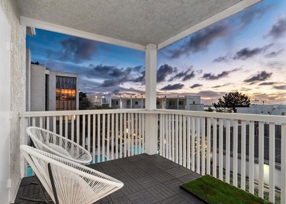 View from a balcony overlooking residential buildings at sunset.