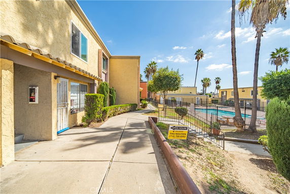 View of a residential building exterior with a swimming pool in the vicinity.