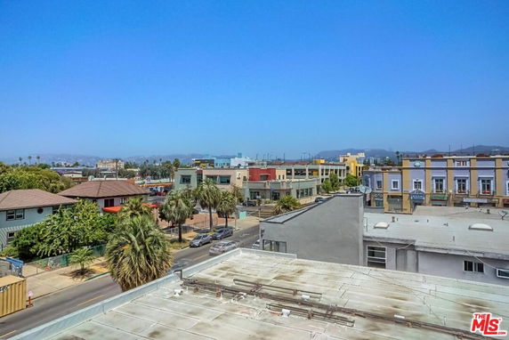 Panoramic view of a cityscape with various buildings and a clear blue sky.