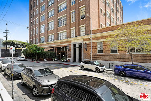 Front view of a multi-story brick building with large windows.