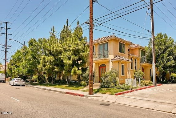 Front view of a two-story house with balconies and a tiled roof.