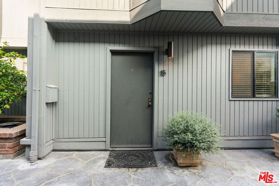 Front view of a house entrance with grey paneling and a single door.