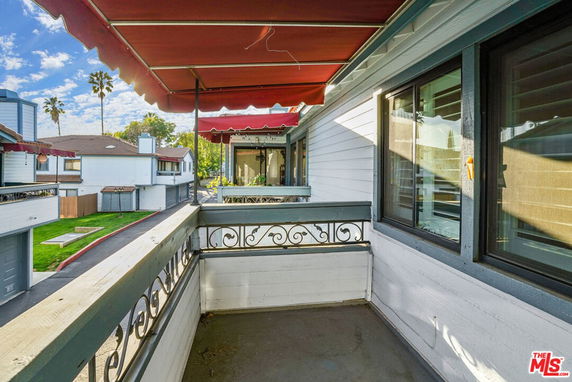 Balcony view of residential area with two-story houses and red awnings.