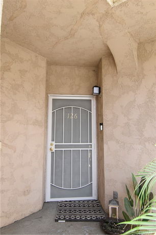 Front view of a house entrance with a decorative metal screen door.