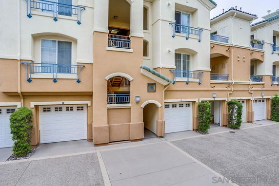 Front view of a multi-story residential building with garages.