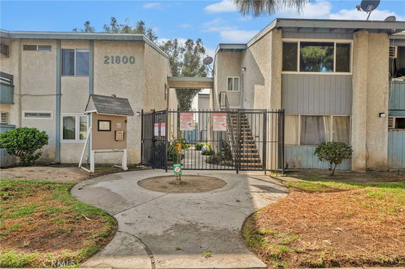 Front view of a multi-story apartment building with a gated entrance.