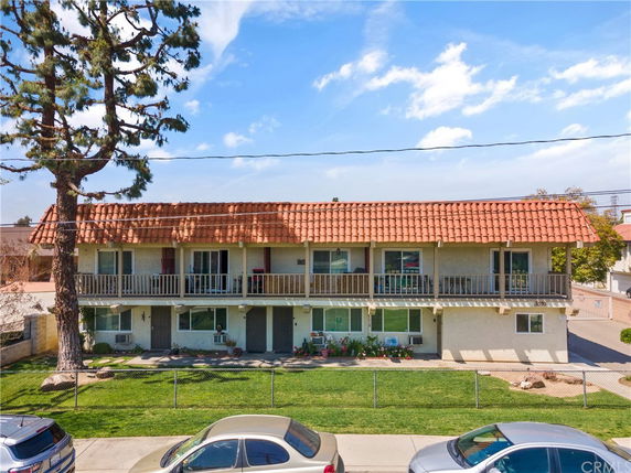 Front view of a two-story building with a red-tiled roof and balconies.