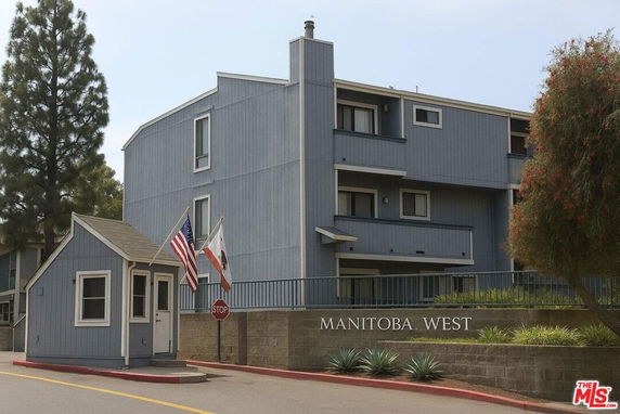 Front view of a multi-story building named Manitoba West with a small guardhouse at the entrance.