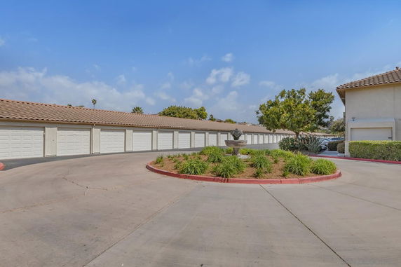 Outdoor parking area with multiple garage doors and a central fountain island.