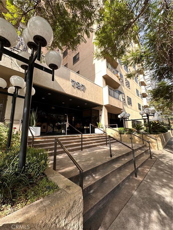 Front view of a multi-story building with entrance stairs and a canopy.