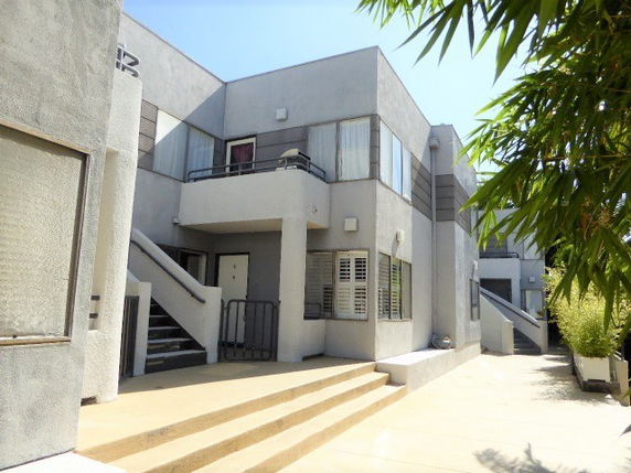 Front view of a multi-story building with staircases leading to the entrances.