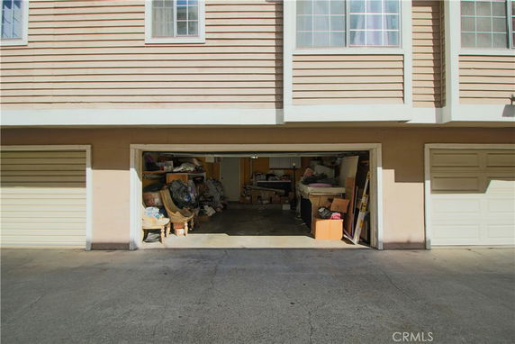Front view of a garage with an open door in a multi-story building.