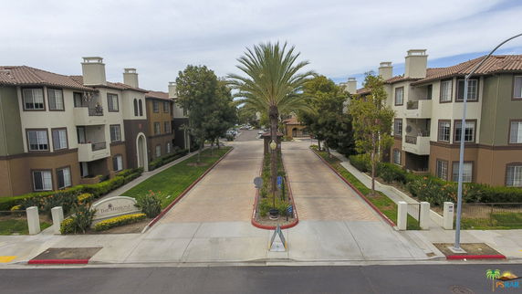 Front view of a residential building complex with multiple three-story buildings and a central walkway.