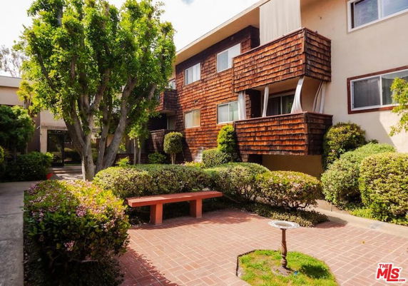 Front view of a two-story apartment building with wooden accents and balconies.